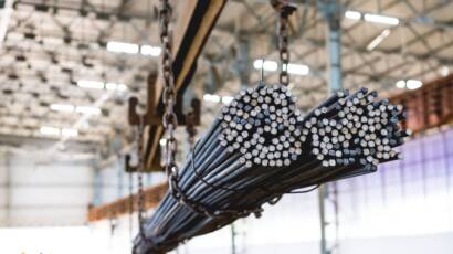 A pile of steel rods hanging on a metal structure at a manufacturing company