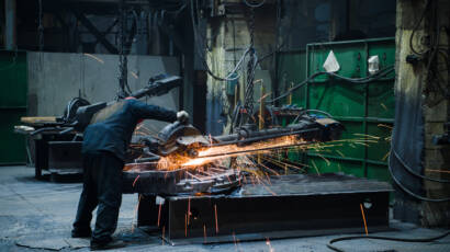 Industrial workers with work tool. Big chainsaw in hands at steel factory