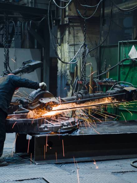 Industrial workers with work tool. Big chainsaw in hands at steel factory